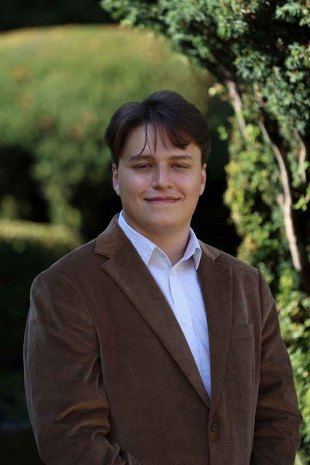 Finn Fairbairn outdoors in a brown jacket