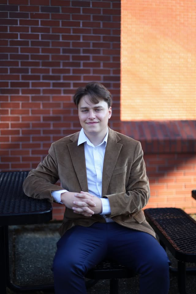 Finn seated outdoors beside a brick wall